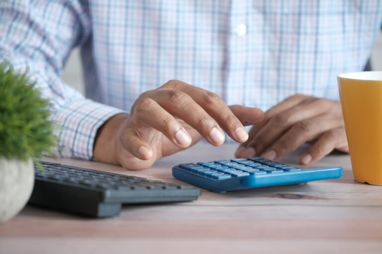 Personne utilisant une calculatrice à son bureau